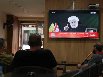 Orang-orang menyaksikan Wakil Pemimpin Hezbollah, Sheikh Naim Qassem, menyampaikan pidato yang disiarkan di televisi, saat mereka duduk di sebuah kafe di Beirut, Lebanon, 15 Oktober 2024. REUTERS/Mohamed Azakir
