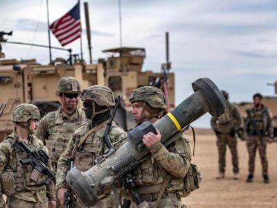 Seorang tentara Amerika membawa peluncur Javelin saat latihan militer antara Pasukan Demokratik Suriah (Syrian Democratic Forces) dan koalisi internasional pimpinan AS melawan kelompok Daesh, di wilayah pedesaan Deir Ezzor, timur laut Suriah, pada 7 Desember 2021. Sumber foto : AFP.